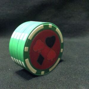 Зелен метален гриндер покер чип със символи на карти върху червен фон