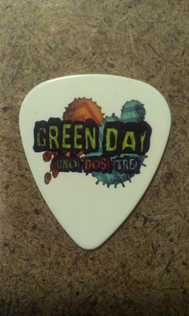 Бяло пънк рок перце за китара Green Day с лого ¡Uno! ¡Dos! ¡Tré! и цветни графични елементи