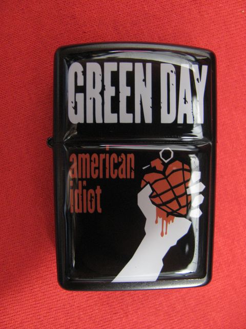 Черна бензинова запалка Green Day с ръка, държаща граната-сърце