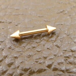 Златна стоманена обица тип стрела с два конуса върху кожена повърхност