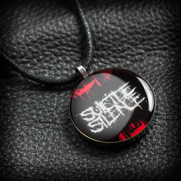 Кръгъл метален медальон на Suicide Silence с бяло лого и червени пръски под смола