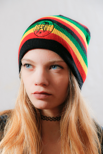 Момиче с плетена раста шапка Bob Marley с цветни ивици и черна основа