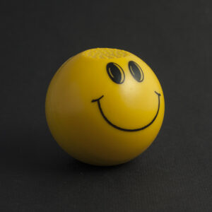 Кръгъл метален гриндер жълто усмихнато лице Smiley на черен фон