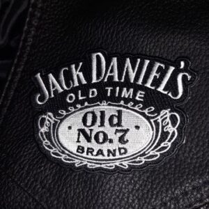 Класическа бродирана нашивка Jack Daniel's върху черна кожа.