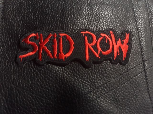 Нашивка Skid Row с червено бродирано лого върху черна кожа.