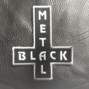 Бродирана нашивка с обърнат кръст и надпис Black Metal върху черен плат.