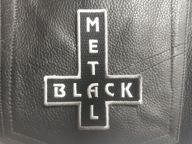Бродирана нашивка с обърнат кръст и надпис Black Metal върху черен плат.