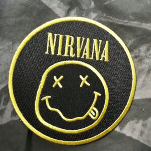 Кръгла бродирана нашивка Nirvana Smiley Logo с жълт надпис и усмихнато лице върху черен плат.