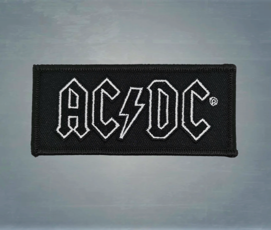 Класически пач за дрехи на AC/DC – бяло лого със светкавица, извезано върху правоъгълна черна основа.