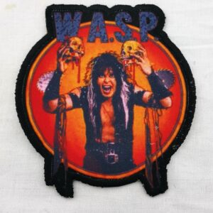 Нашивка W.A.S.P. с Блеки Лоулес, държащ черепи, на огнен фон.