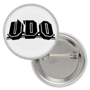 Метална значка на U.D.O. с черно лого на бял фон