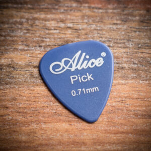 Синьо перце за китара Alice Pick 0.71mm с бяло лого върху дървена повърхност