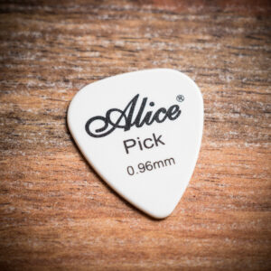 Бяло перце за китара Alice Pick 0.96mm с черно лого върху дървена повърхност