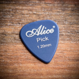 Твърдо синьо перце за китара Alice 1.20 mm поставено върху дървен фон