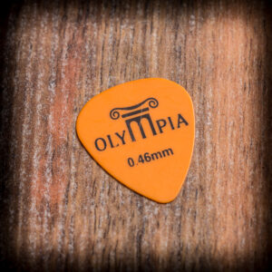 Тънко оранжево перце за китара Olympia 0.46 mm върху дървена повърхност