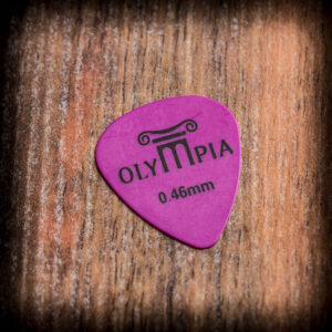 Тънко лилаво перце за китара Olympia 0.46 mm върху дървена повърхност