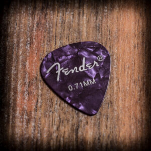 Лилаво перце за китара Fender 0.71 mm с перлен ефект върху дървен фон