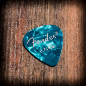 Синьо перлено перце за китара Fender 0.71 mm върху дървена повърхност