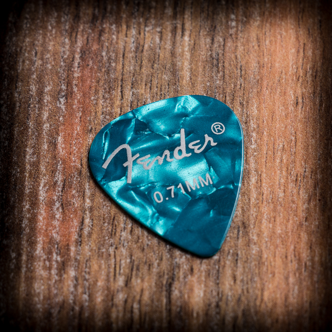 Синьо перлено перце за китара Fender 0.71 mm върху дървена повърхност