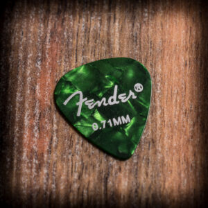 Зелено перце за китара Fender 0.71mm Medium върху дървена повърхност