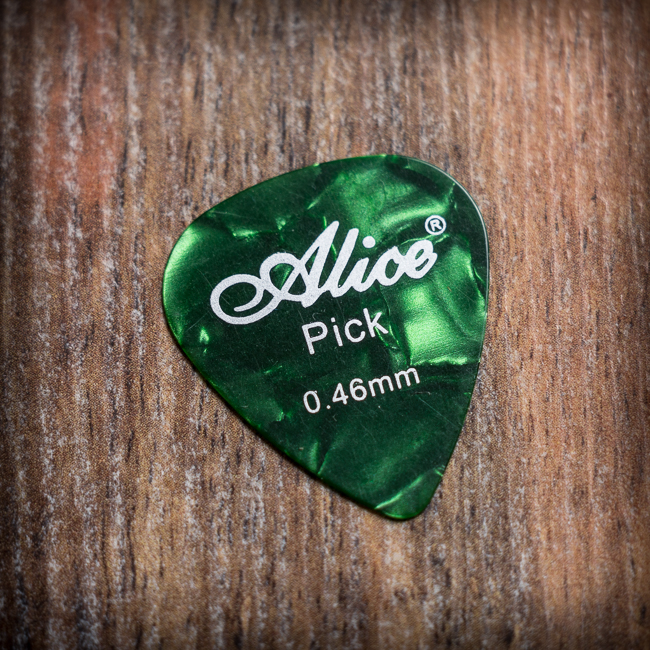 Зелено перце за китара Alice 0.46mm с мраморен ефект върху дървена повърхност