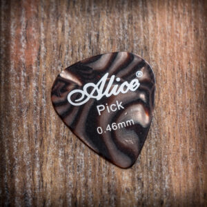 Кафяво тигрово перце за китара Alice 0.46mm с ивичест мраморен ефект върху дървена повърхност
