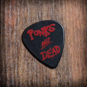 Черно перце за китара Punks Not Dead с червени букви върху дървен фон