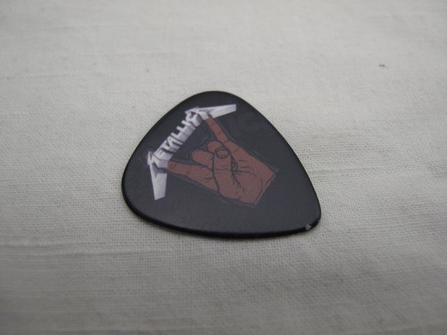 Черно китарно перце Metallica с матово покритие и принт "рогата" върху сив фон.
